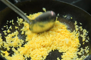 大火加熱炒鍋，再入油，燒到四至五成熱時(shí)倒入雞蛋液，在未凝結(jié)之前，加米飯煸炒，不停翻炒并用鍋鏟將成塊的米飯碾開(kāi)、撥散。