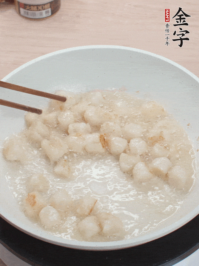 油溫4成熱，鮮貝蘸干淀粉下鍋煎，一面微黃后翻面。