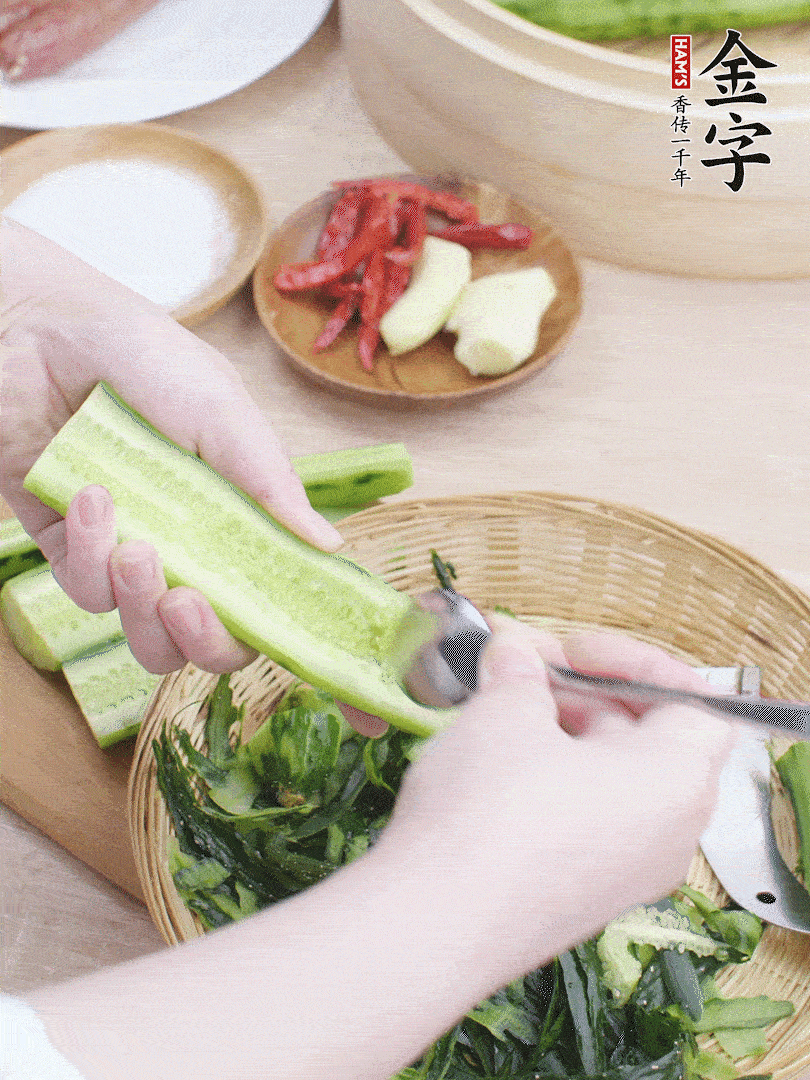 黃瓜削皮，對半切開，勺子挖去內(nèi)瓤，斜刀切片。青蒜斜刀切段。