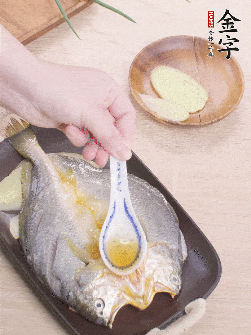 盤(pán)底鋪姜片，放黃魚(yú)，淋2勺料酒。