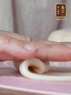 做面劑 油皮按扁，中間包入一個(gè)油酥，邊緣收緊捏死。包好的面劑按扁，用搟面杖搟壓成橢圓形。從底部向上卷成筒狀，用保鮮膜蓋好松弛15分鐘，再把筒狀縱向搟壓成長(zhǎng)條狀。再卷一次，松弛20分鐘