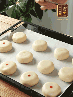 收口向下放在案板上，輕輕將月餅坯按扁，用筷子點(diǎn)紅點(diǎn)做裝飾