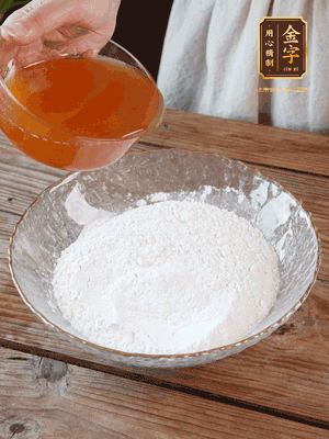 轉(zhuǎn)化糖漿、枧水、花生油攪拌均勻，加入面粉混合，醒發(fā)2小時。捏成23g一個的小球