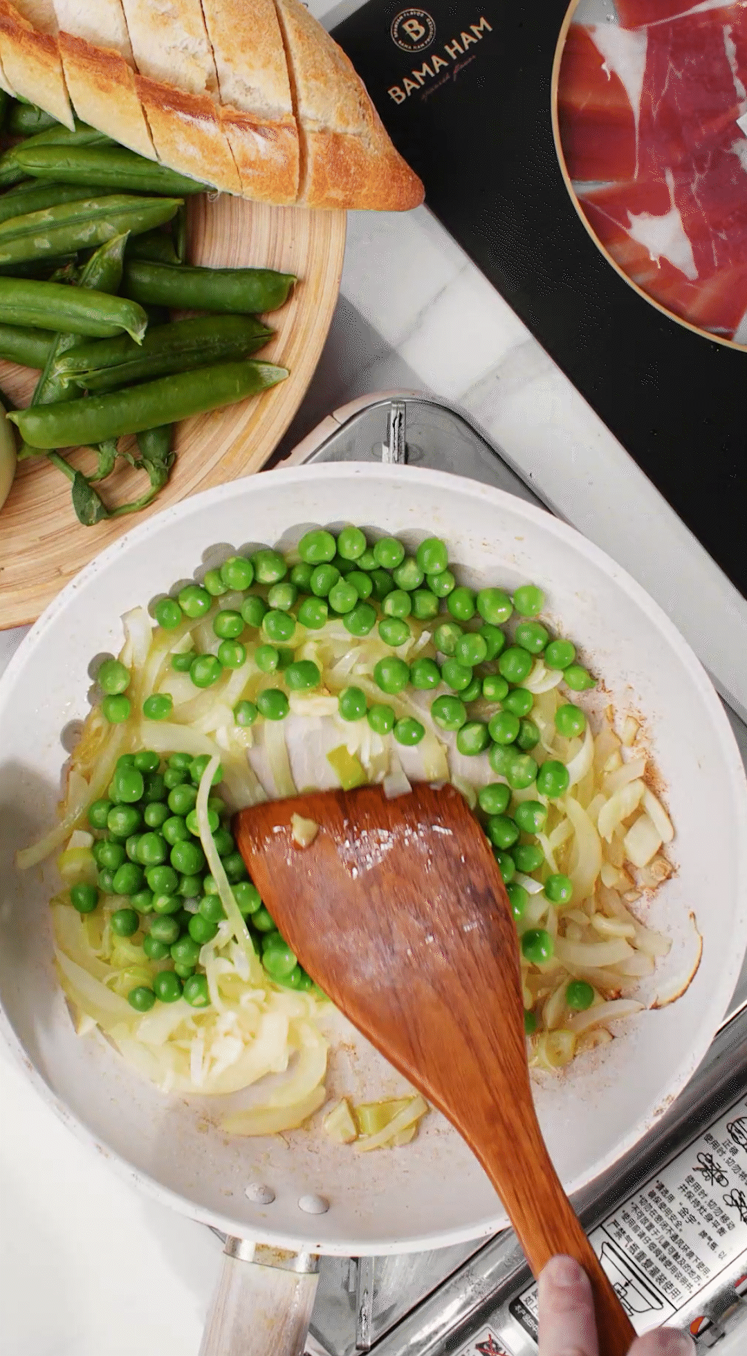 鍋中放入黃油融化，加入洋蔥絲、大蔥蔥白絲、蒜末翻炒變軟出香味。加入剛剛汆燙冰鎮(zhèn)后的豌豆，取出一點(diǎn)點(diǎn)待會(huì)擺盤裝飾用。加一點(diǎn)鹽 (和黑胡椒) 調(diào)味。