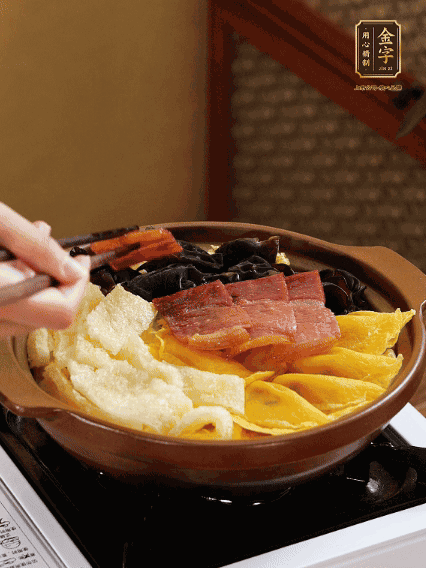 砂鍋底部鋪上娃娃菜，依次擺上肉皮、蛋餃、黑木耳、火腿