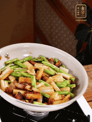 油熱下蒜末、干辣椒、醬肉煸炒出香味，依次下藕條、豆角翻炒均勻